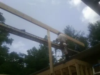 Carpenter setting a ridge beam over a new addition frame — Ice Dam Removal by Roofing Brothers in Copalis Beach
